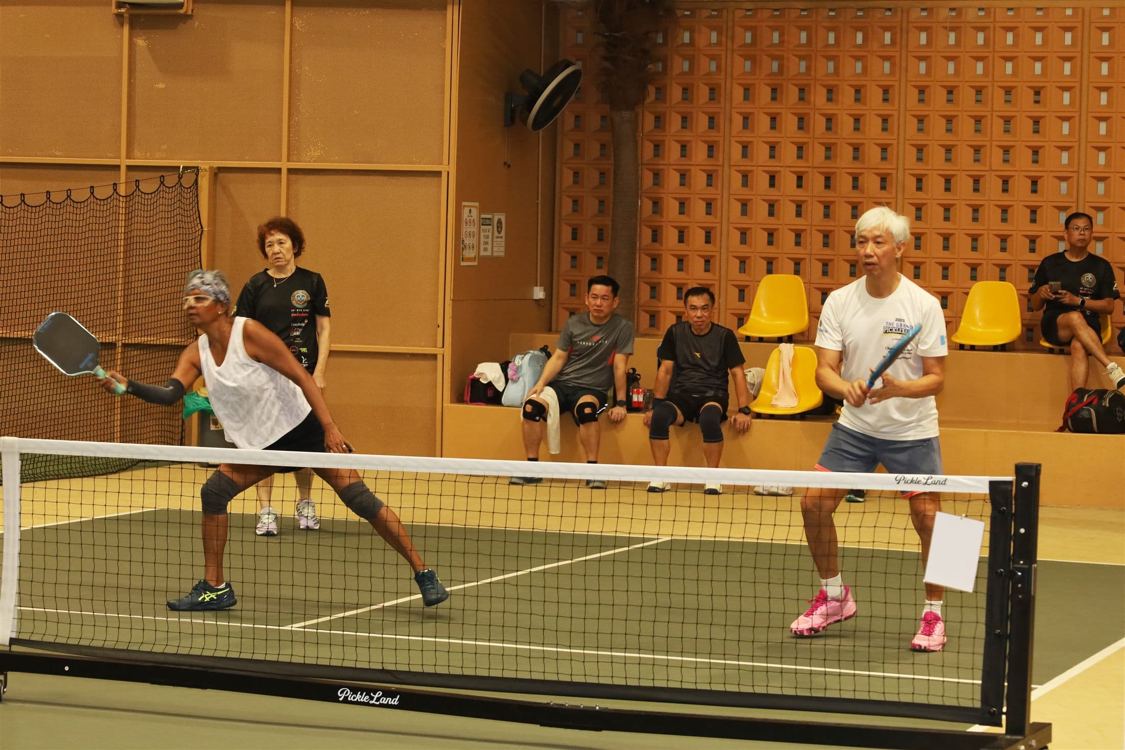 Members rallying at the net during a doubles match