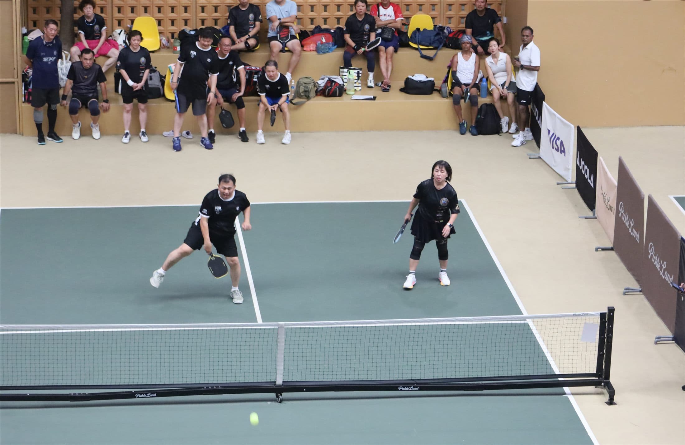Doubles players in action with the crowd watching
